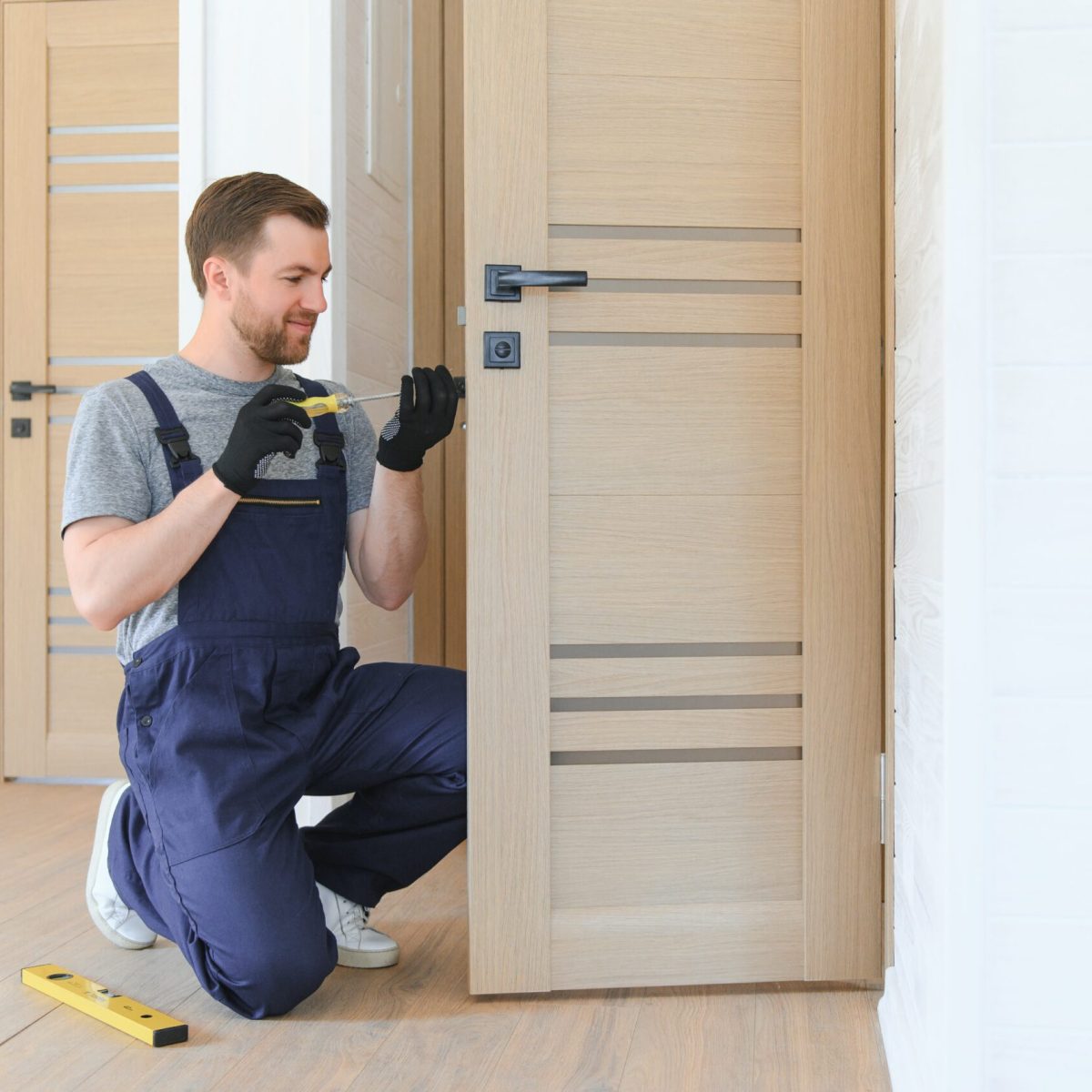 handsome young man installing a door in a new house construction site.